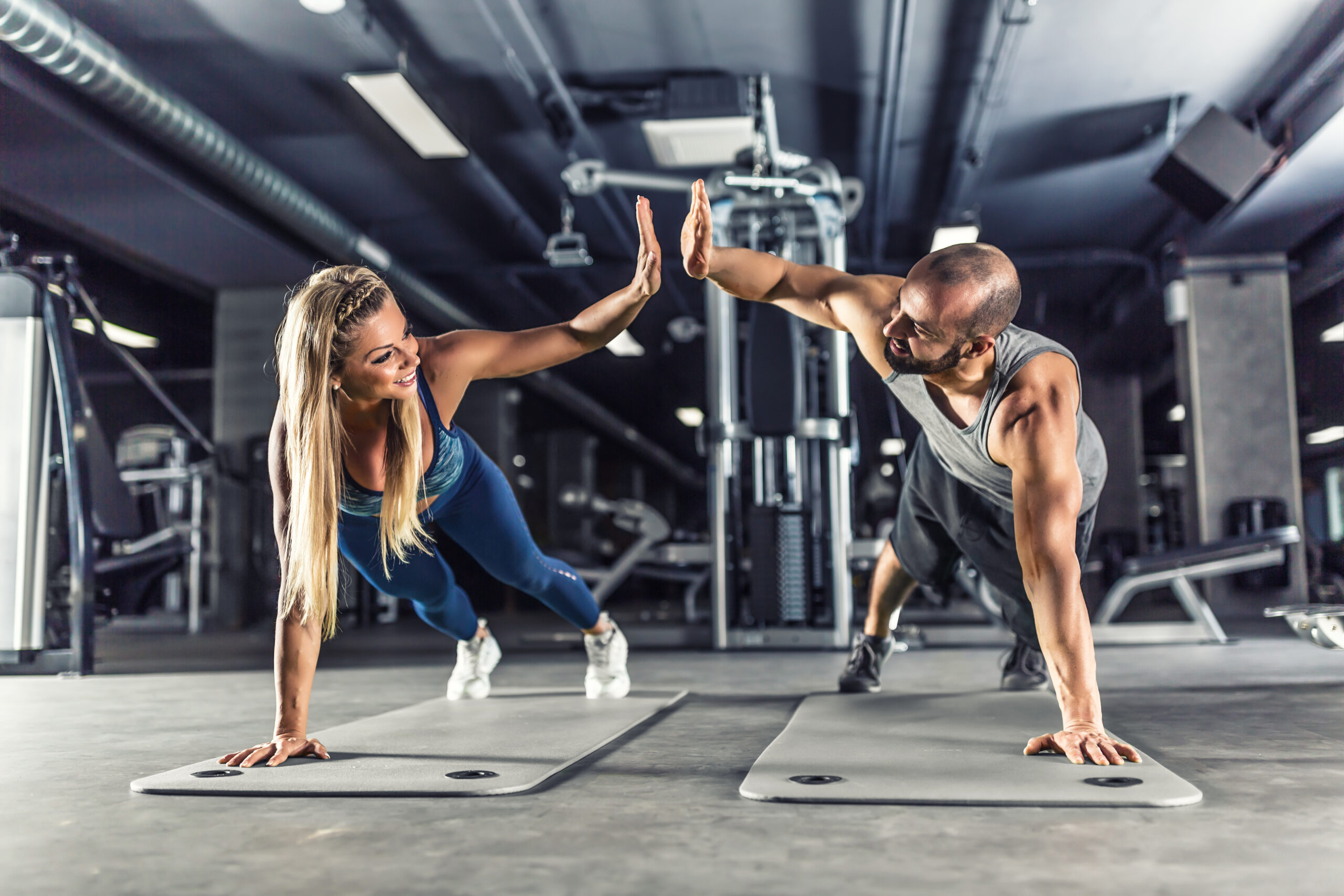 Sport couple doing plank exercise workout in fitness centrum. Man and woman practicing plank in the gym tarzana, ca